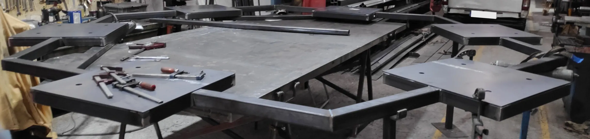 Estructura metálica en fabricación sobre la mesa del taller, con sargentos de sujeción